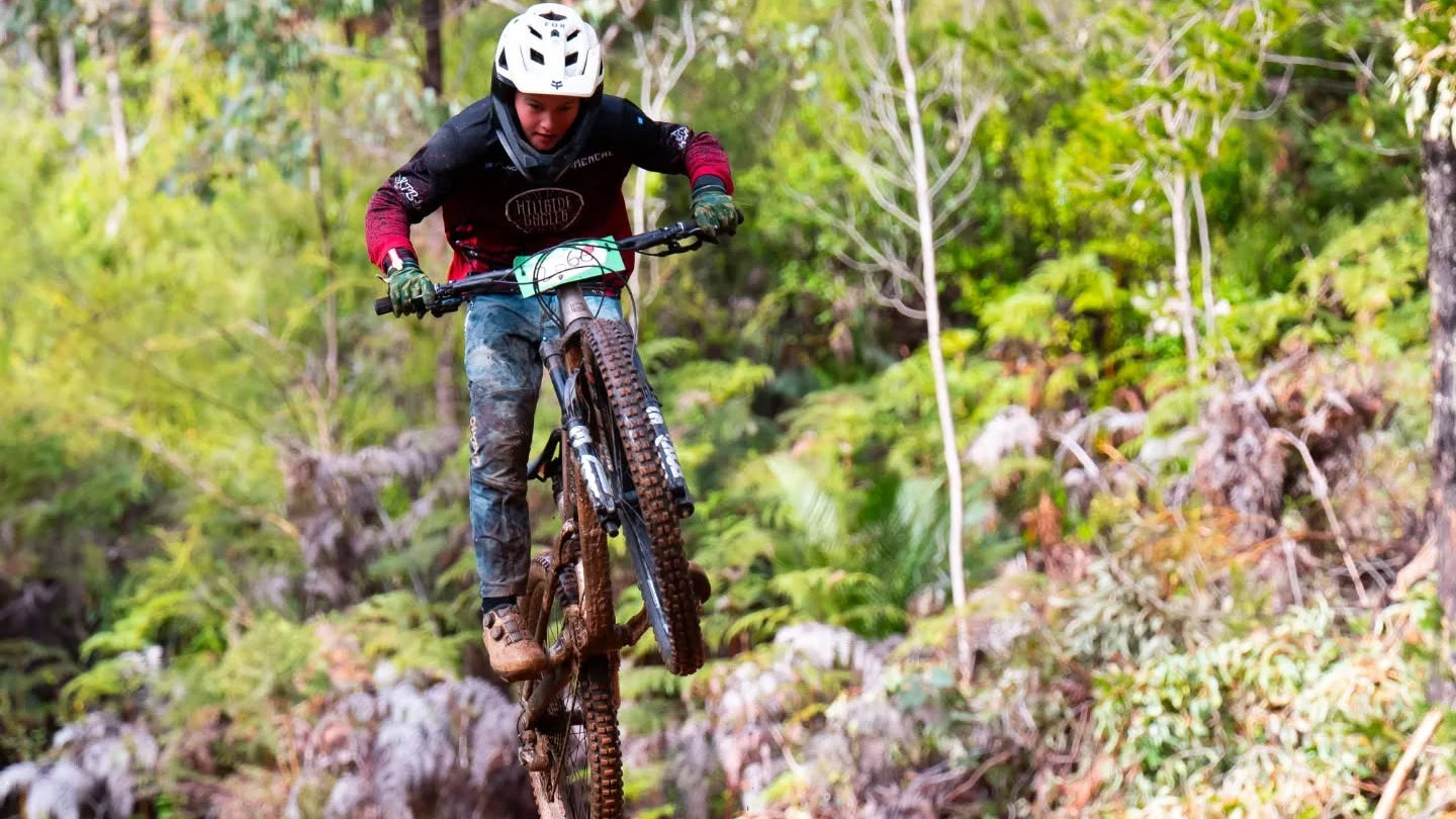 young hillside cyclist jumping on a mountain bike